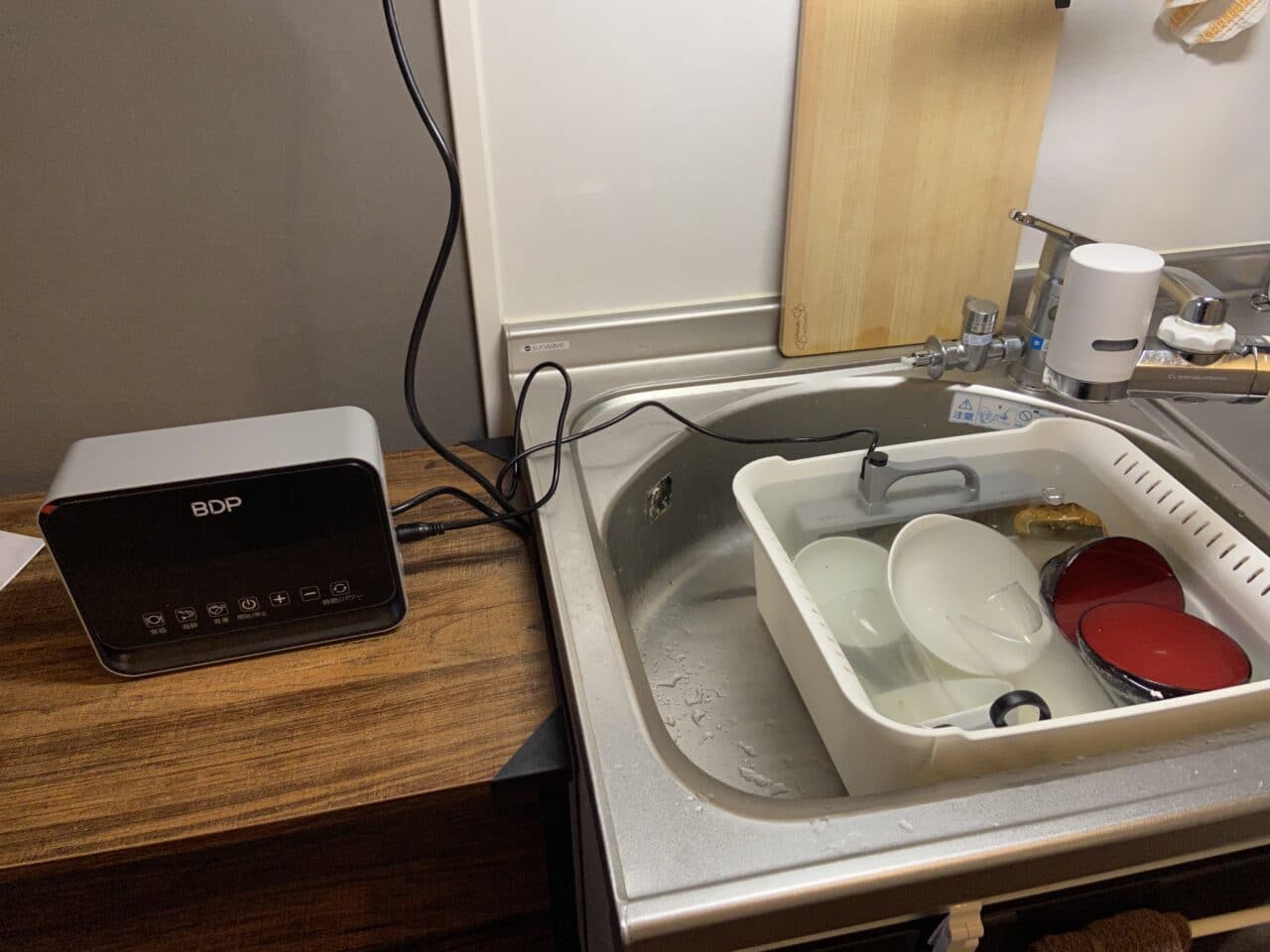 キッチンシンクにBDPデバイスが置かれており、洗い物用の容器と食器が収納されている。
